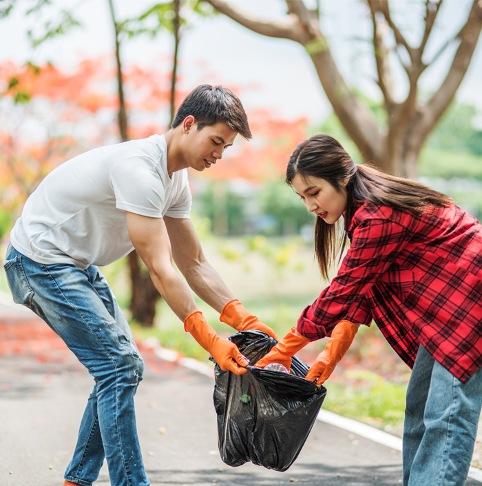 Two people in gloves bagging up rubbish during a property clean-up