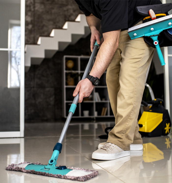 Cleaner mopping a tiled floor inside a home